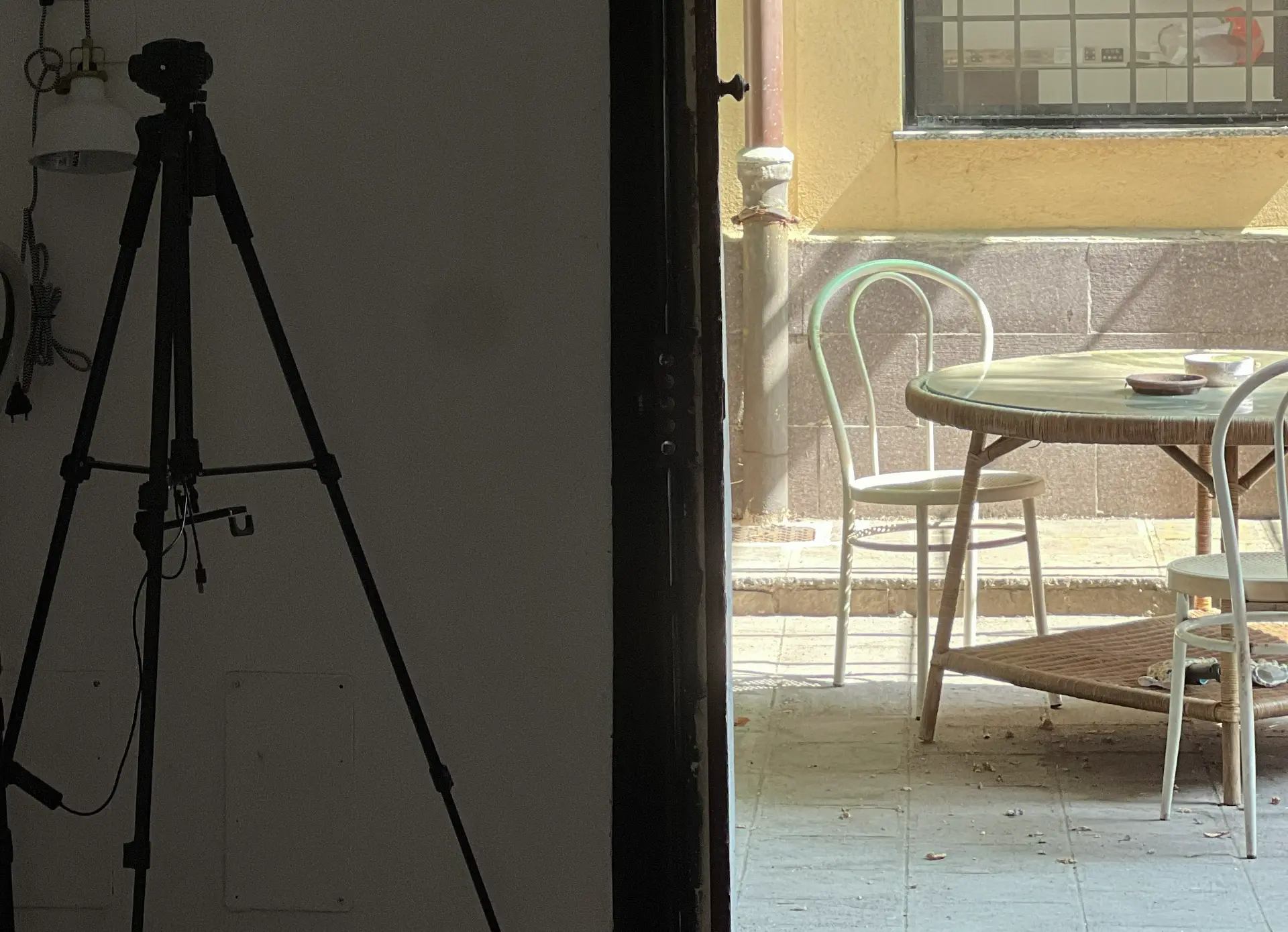 Il cortile interno della sede di Via Carlo d'Adda, con tavolo e sedie bagnate dal sole.